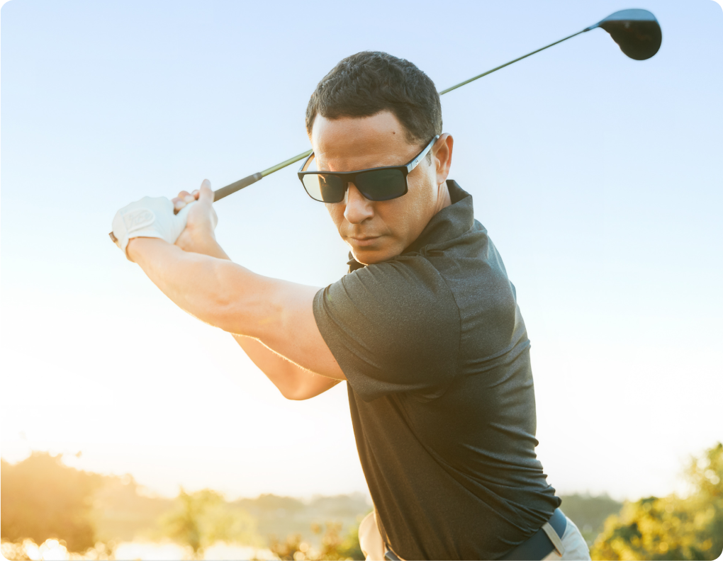 Man wearing sunglasses golfing