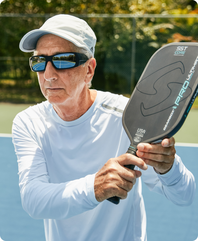 Man wearing sunglasses playing pickleball