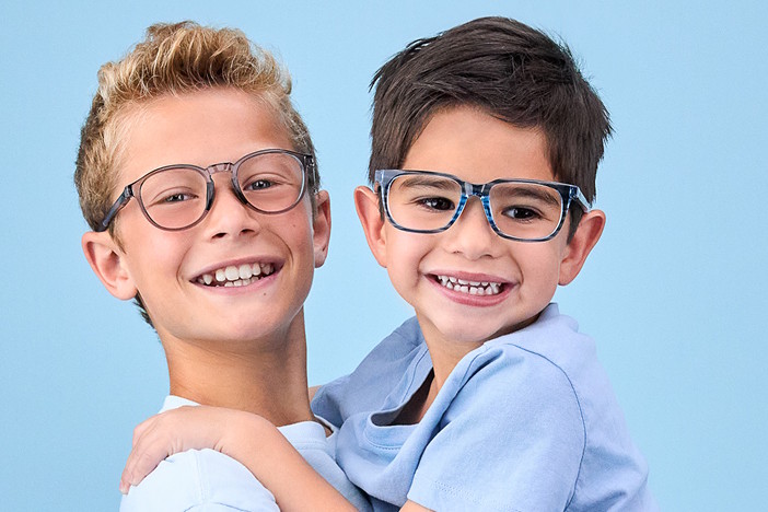 An older kid with glasses, carrying a younger kid with glasses.